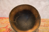 Hand-carved vintage African wooden bowl, showing its dark interior and aged wood texture.