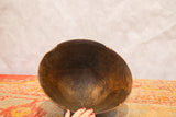 Vintage African wooden bowl interior, showcasing hand-carved wood grain and aged cracks.