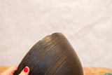 Aged dark wood African bowl detail with hand-carved lines and organic edge imperfections.