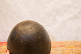 Vintage African wooden bowl’s dark, primitive surface showing visible cracks and metal repairs.