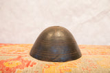 Primitive hand-carved dark wood African bowl showing concentric lines and a visible crack.