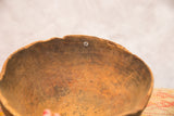 Vintage wooden African bowl interior with aged patina, distinct grain, and small repair.