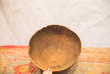 Primitive interior of the vintage African wooden bowl with visible cracks, touched by a hand.