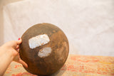 Vintage African wood bowl with dark, aged surface and metal repairs.