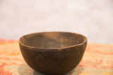 Aged, hand-carved dark wood texture and rim of a vintage African bowl.