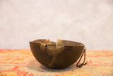 Vintage African wooden bowl with characterful brass repairs and visible aged cracks.