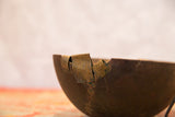 Vintage wooden African bowl detail highlighting aged dark wood, brass attachments, and crack repairs.