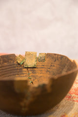 Detail of primitive hand-carved African bowl, showing crack and brass attachments.