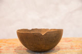 Primitive vintage African bowl with dark brown wood and rustic, chipped rim.