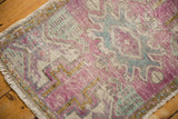 Distressed vintage Oushak rug pile featuring mauve, sea foam green, gold, and ivory.