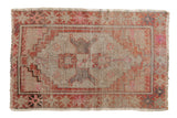 Distressed vintage Oushak rug with a diamond medallion in burnt orange, pink, and beige.