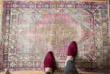Vintage distressed Oushak rug with faded aubergine, sea foam, and ivory stepped medallion.