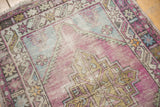 Faded aubergine field with stepped geometric medallion on distressed Oushak rug.