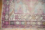 Distressed Oushak rug corner with geometric border, low pile wear, aubergine, mint, ivory.