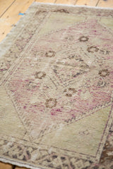 Distressed vintage Oushak rug texture displaying pale mauve and antique ivory with even wear.