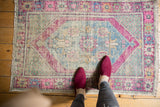Decorative distressed Oushak rug: central diamond medallion with soft pink, blue, and mint.
