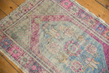 Distressed Oushak rug detail showing wear with bright pink, sky blue, and pale gold hues.