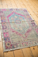 Designer-aligned distressed Oushak rug corner with vibrant pink, blue, mint border.