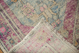 Hand-knotted distressed Oushak rug corner revealing even wear, foundation, and side selvage.