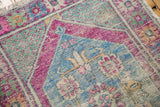 Distressed Oushak rug texture, showing worn knot heads, faint foundation, and vibrant pink, blue, mint green.