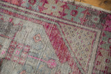 Distressed texture with vibrant fuchsia and muted mint geometric patterns over a beige ground.