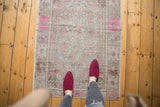 Vintage distressed Oushak rug with faded pink, blue, and mint green medallion design.