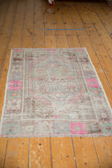 Distressed vintage Oushak rug's secured fringe, showcasing pink, ivory, and mauve hues.