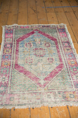 Distressed vintage Oushak rug close-up, highlighting faded aubergine, blue, and mint green pile.