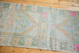Distressed Oushak runner's central plain-woven connection showcasing even wear and soft hues.