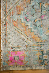 Distressed vintage Oushak runner texture, showing even wear, bubble gum pink, orange, and blue.