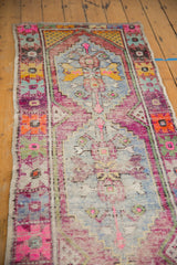 Textured pile of a distressed Oushak runner, showing worn knot heads, foundation, and vibrant colors.