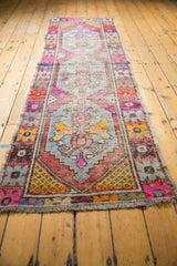 Secured fringe end of the vintage Oushak runner with playful distressed pile.