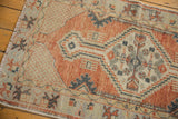 Vintage Oushak rug runner's distressed brick red field and geometric medallion design.