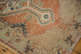Distressed pile texture showing brick red, antique ivory, and charcoal navy geometric patterns.