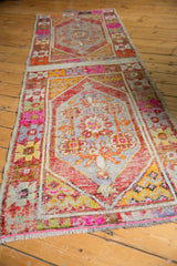 Distressed Oushak runner's original side selvage, worn texture, and vibrant pink and orange colors.
