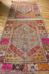 Vibrant distressed vintage Oushak runner, 'double carpet' construction with pink and rust medallions.