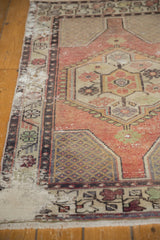 Decorative distressed Oushak rug corner showcasing apricot, ivory, and intricate vinery.