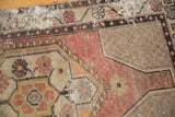 Distressed Oushak rug detail with textured apricot pile, visible wear, and beige spandrel vinery.