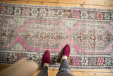 Vintage distressed Oushak runner, its worn medallion pattern in soft mauve, ivory, silver.