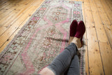 Vintage distressed Oushak runner, central medallion with soft mauve, grey, ivory tones.