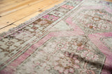 Distressed Oushak runner's worn pile, revealing foundation and soft mauve, silver tones.