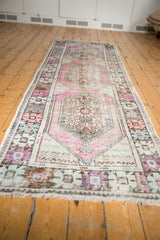 Distressed vintage Oushak runner end, showcasing soft ivory fringe and geometric blush, mint border.