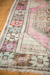 Close-up of vintage Oushak runner's distressed pile, revealing pale grape, mint, and blush geometric patterns.