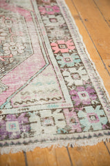 Vintage distressed Oushak runner detail, showing textured pile with mauve, mint, and ivory.