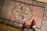 Distressed Turkish Oushak rug, showing worn pile texture, pale apricot mauve, and antique ivory.