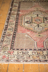 Distressed apricot mauve and ivory Oushak rug corner with intricate vinery motif.