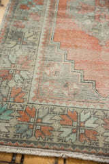 Worn Oushak runner corner detail, showing apricot field and mint green floral pinwheel motifs.