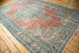 Distressed vintage Oushak carpet, revealing overall worn texture with brick red, blue, and mint green.