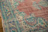 Textured brick red field with distressed patina and ornate blue-green border of a vintage Oushak.
