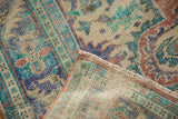 Distressed Oushak rug pile with royal blue, mint green, brick red, showing foundation and fringe.
